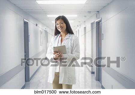 Asian doctor smiling in hospital View Large Photo Image Stock Image - Asian doctor smiling in hospital. Fotosearch