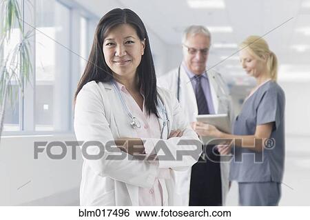 Asian doctor smiling in hospital View Large Photo Image Stock Photograph - Asian doctor smiling in hospital. Fotosearch