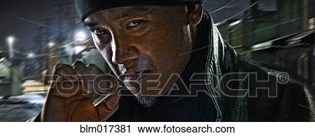 Asian man smoking on city street View Large Photo Image Stock Image - Asian man smoking on city street. Fotosearch