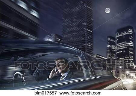 Stock Photo - Caucasian businessman driving on cell phone. Fotosearch