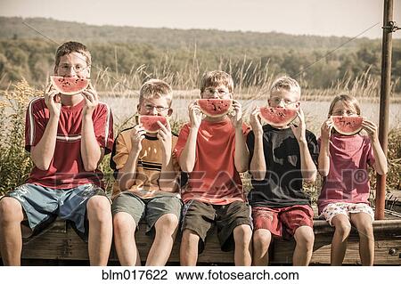 Caucasian children eating watermelon outdoors View Large Photo Image Stock Image - Caucasian children eating watermelon outdoors. Fotosearch
