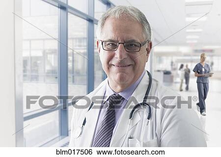 Stock Photograph - Caucasian doctor smiling in hospital. Fotosearch
