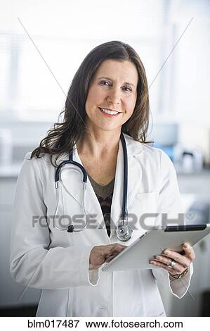 Caucasian doctor using tablet computer in office View Large Photo Image Stock Photo - Caucasian doctor using tablet computer in office. Fotosearch