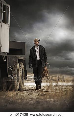 Stock Photo - Caucasian farmer walking by truck. Fotosearch