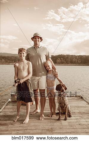 Stock Photo - Caucasian father, children and dog smiling together. Fotosearch