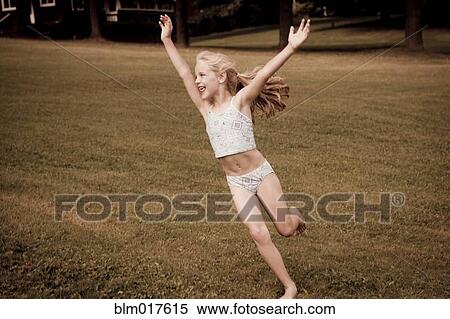 Caucasian girl playing in grassy field View Large Photo Image Stock Photography - Caucasian girl playing in grassy field. Fotosearch
