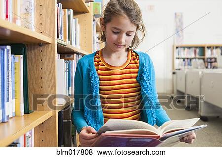 Caucasian girl reading book in library View Large Photo Image Stock Photo - Caucasian girl reading book in library. Fotosearch