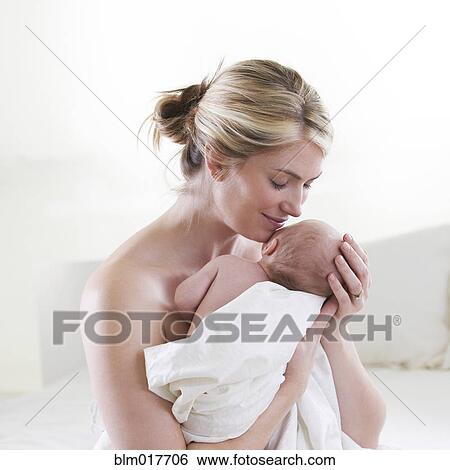 Stock Photograph - Caucasian mother cradling baby. Fotosearch