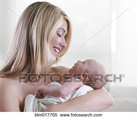 Stock Photography - Caucasian mother cradling baby. Fotosearch
