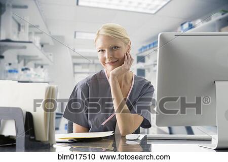Caucasian nurse working at computer in hospital View Large Photo Image Stock Image - Caucasian nurse working at computer in hospital. Fotosearch