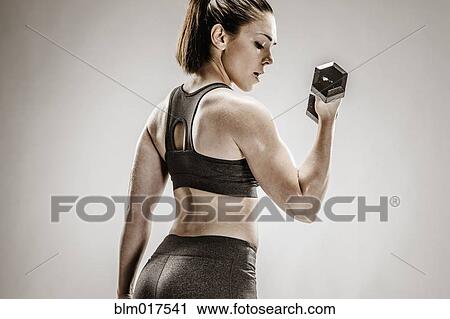 Stock Image - Caucasian woman lifting weights. Fotosearch