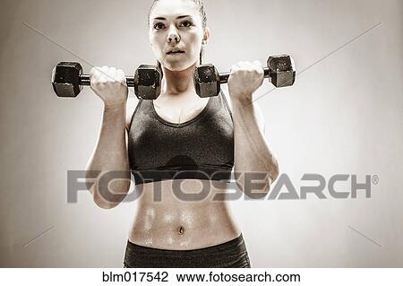 Stock Image - Caucasian woman lifting weights. Fotosearch