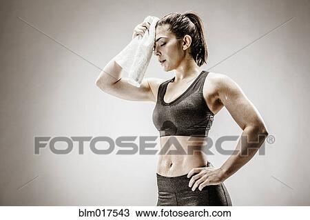 Caucasian woman wiping sweat from forehead View Large Photo Image Stock Image - Caucasian woman wiping sweat from forehead. Fotosearch