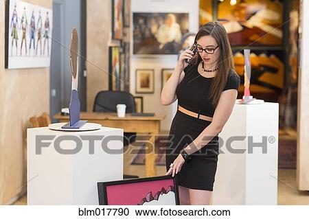 Stock Image - Caucasian woman working in art gallery. Fotosearch