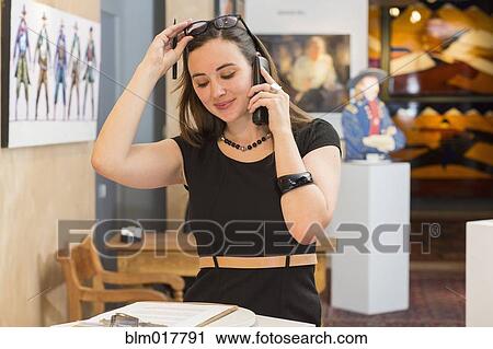 Stock Image - Caucasian woman working in art gallery. Fotosearch