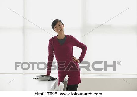 Chinese businesswoman smiling in office View Large Photo Image Stock Photography - Chinese businesswoman smiling in office. Fotosearch