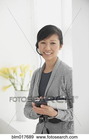Stock Photo - Chinese businesswoman talking on headset. Fotosearch