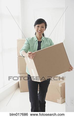 Chinese woman carrying box in new home View Large Photo Image Stock Photograph - Chinese woman carrying box in new home. Fotosearch