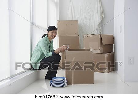 Chinese woman unpacking boxes in new home View Large Photo Image Stock Image - Chinese woman unpacking boxes in new home. Fotosearch