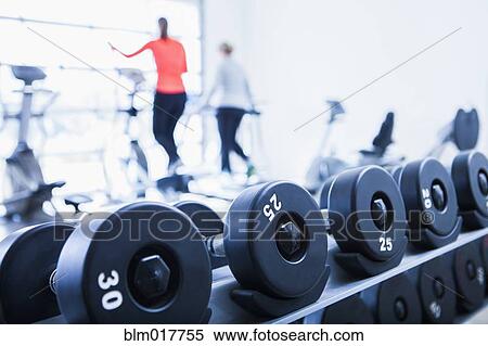 Stock Photography - Close up of dumbbells on rack in gym. Fotosearch