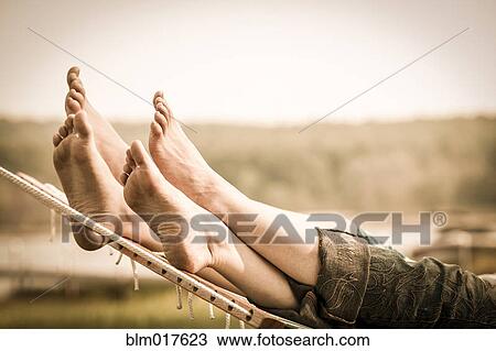 Stock Image - Close up of mother and child's feet in hammock. Fotosearch