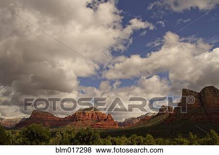 Stock Photo - Clouds over rock formations in rural landscape, Sedona, AZ, United States. Fotosearch