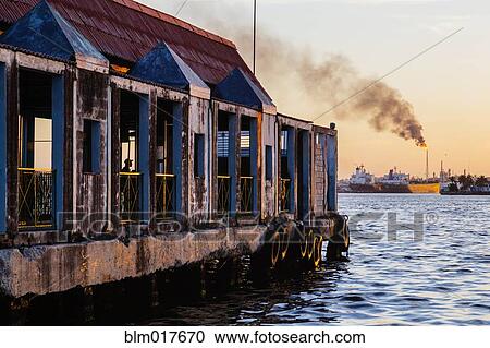 Stock Image - Dilapidated building on urban waterfront. Fotosearch