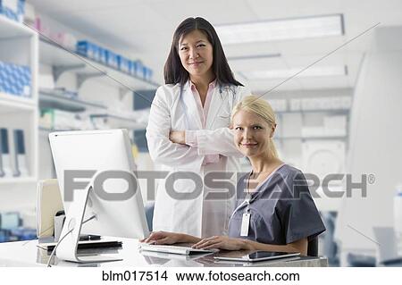 Picture - Doctor and nurse smiling at computer in hospital. Fotosearch