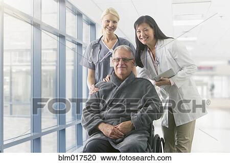 Doctor and nurse smiling with patient in hospital View Large Photo Image Stock Image - Doctor and nurse smiling with patient in hospital. Fotosearch