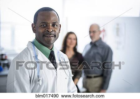 Stock Image - Doctor and patients standing in office. Fotosearch