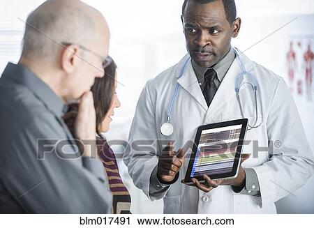 Doctor showing tablet computer to patients View Large Photo Image Stock Image - Doctor showing tablet computer to patients. Fotosearch