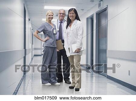 Stock Photo - Doctors and nurse smiling in hospital. Fotosearch