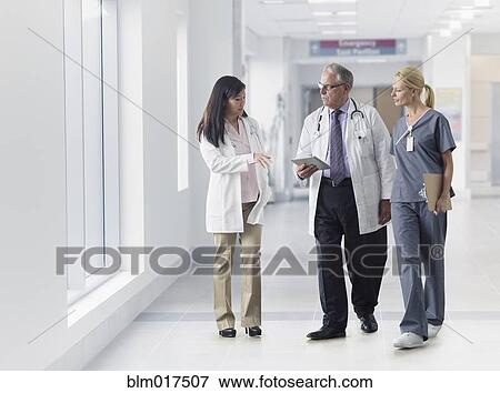Stock Photo - Doctors and nurse talking in hospital. Fotosearch