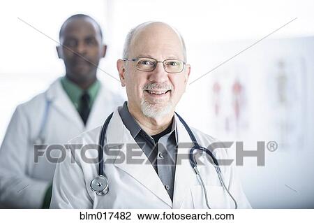Stock Image - Doctors smiling in office. Fotosearch
