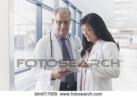 Stock Photography - Doctors using tablet computer in hospital. Fotosearch