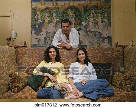 Stock Image - Family smiling together in living room. Fotosearch