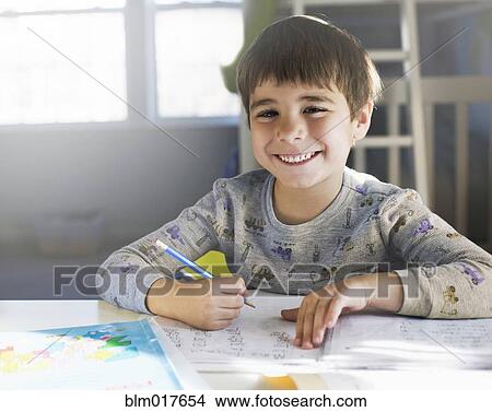 Picture - Hispanic boy doing homework at desk. Fotosearch