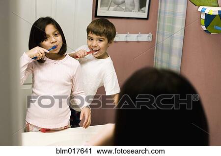 Stock Image - Hispanic children brushing their teeth. Fotosearch