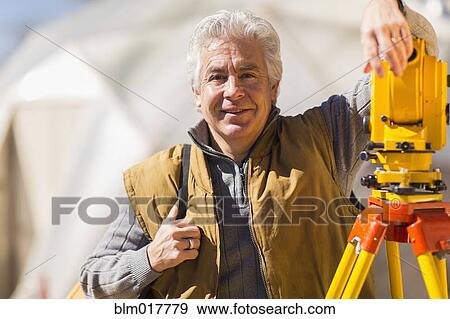 Hispanic surveyor working outdoors View Large Photo Image Stock Photo - Hispanic surveyor working outdoors. Fotosearch