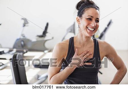 Stock Image - Hispanic woman laughing in gym. Fotosearch