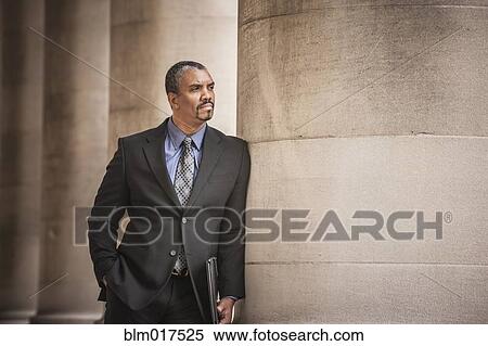 Mixed race businessman leaning on column View Large Photo Image Stock Photography - Mixed race businessman leaning on column. Fotosearch
