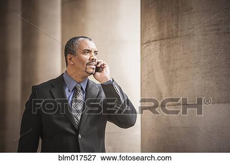 Stock Photo - Mixed race businessman talking on cell phone. Fotosearch