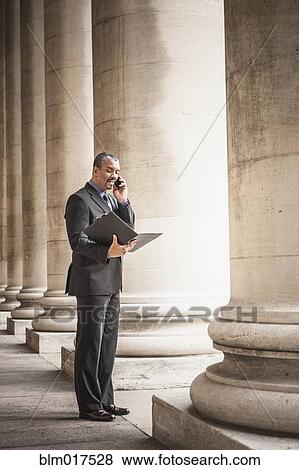 Mixed race businessman talking on cell phone View Large Photo Image Stock Photo - Mixed race businessman talking on cell phone. Fotosearch