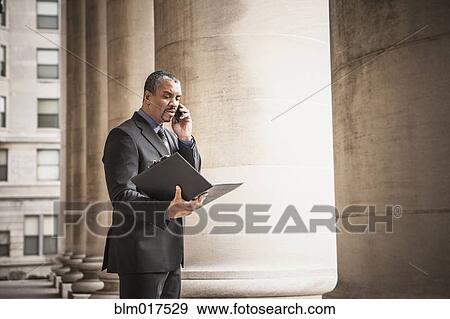 Mixed race businessman talking on cell phone View Large Photo Image Stock Photo - Mixed race businessman talking on cell phone. Fotosearch