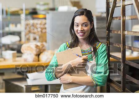 Mixed race woman working in bakery kitchen View Large Photo Image Stock Image - Mixed race woman working in bakery kitchen. Fotosearch