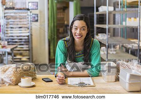 Mixed race woman working in bakery kitchen View Large Photo Image Stock Photograph - Mixed race woman working in bakery kitchen. Fotosearch