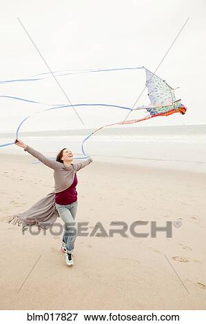 Older Caucasian woman flying kite on beach View Large Photo Image Stock Photo - Older Caucasian woman flying kite on beach. Fotosearch