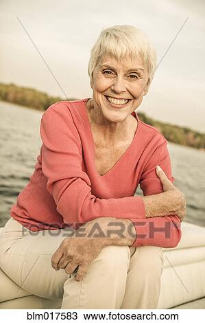Stock Image - Older Caucasian woman smiling on boat. Fotosearch