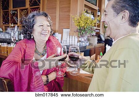Older Hispanic couple having wine at bar View Large Photo Image Stock Photography - Older Hispanic couple having wine at bar. Fotosearch