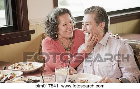 Stock Image - Older Hispanic couple playing in restaurant. Fotosearch